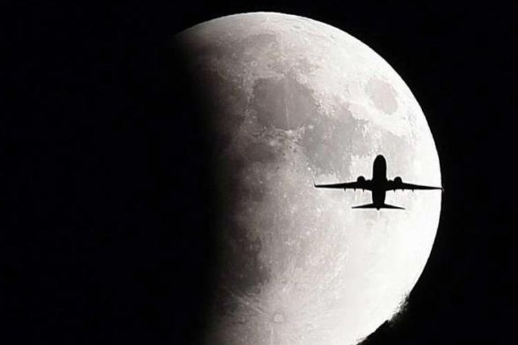 Pesawat terbang dengan latar belakang bulan purnama (supermoon) yang sedang mengalami proses gerhana, Minggu (27/9/2015), di Jenewa, Swiss.