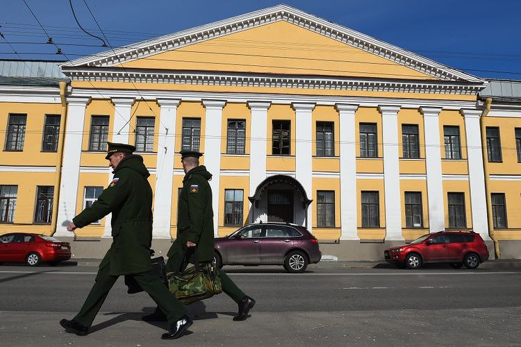 Dua petugas berjalan di depan sebuah gedung di Akademi Militer Mozhaisky di Saint Petersburg, tempat terjadinya ledakan, pada Selasa (2/4/2019).