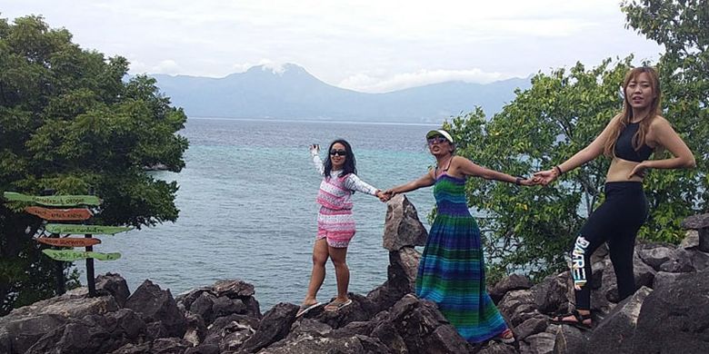 Para wisatawan berswafoto di bukit dan jembatan batu di Pulau Kojadoi, Kabupaten Sikka, Flores, NTT, Senin (3/6/2019).