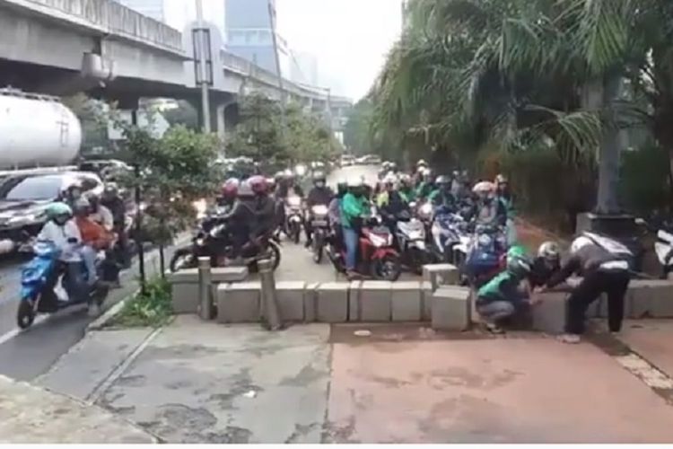 Sejumlah pengendara sepeda motor bergotong royong menggeser beton pembatas di trotoar Jalan Casablanca, Jakarta Selatan, tepatnya di depan Taman Pemakaman Umum Menteng Pulo. Aksi mereka terekam kamera dan videonya kini beredar di media sosial.