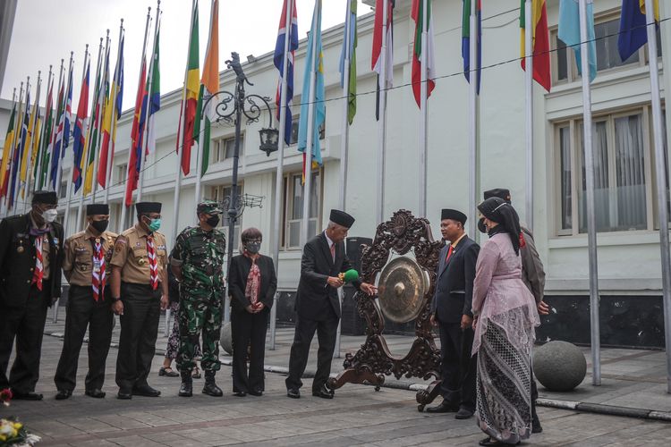 Dirjen Informasi dan Diplomasi Publik Kementerian Luar Negeri Teguh Wardoyo (tengah) didampingi Wakil Gubernur Jawa Barat Uu Ruzhanul Ulum memukul gong sebagai tanda pembukaan rangkaian peringatan 67 tahun Konferensi Asia Afrika (KAA) saat upacara pengibaran bendera peserta KAA di Jalan Sukarno, Bandung, Jawa Barat, Senin (18/4/2022).