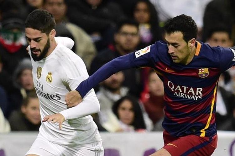 Isco (kiri) dan Sergio Busquets berduel saat Real Madrid bertemu Barcelona pada lanjutan La Liga di Stadion Santiago Bernabeu, Sabtu (21/11/2015).