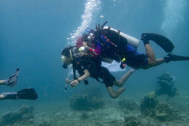 Suasana pengibaran bendera di bawah laut oleh penyandang disabilitas.