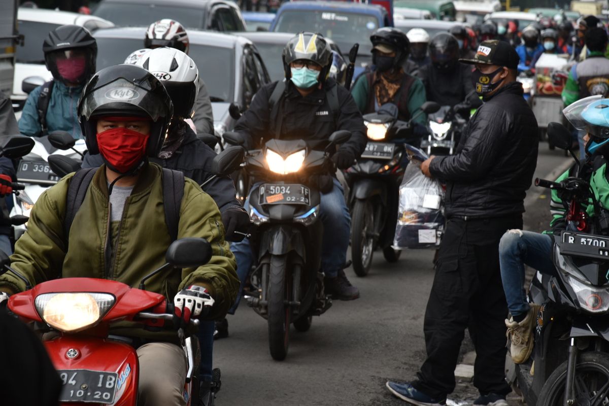 Sejumlah warga menjajakan dagangannya berupa masker dan sarung tangan di pinggir jalan sebelum pemeriksaan petugas di Check Point saat PSBB Jabar diberlakukan, Rabu (6/5/2020).