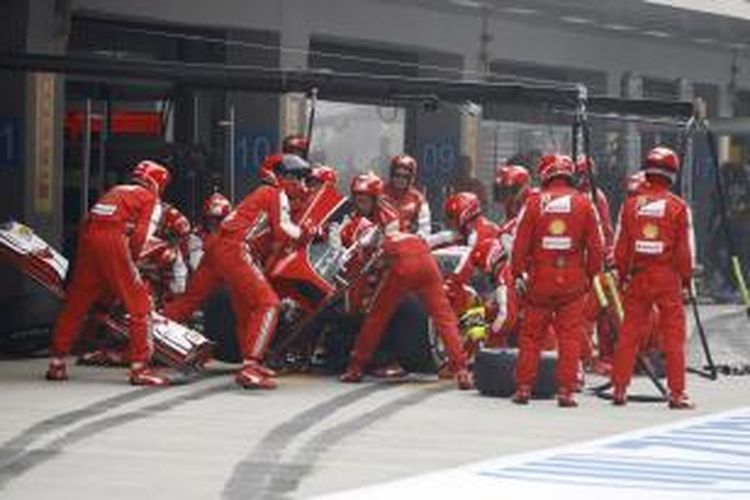 Kru Ferrari tengah memperbaiki mobil Fernando Alonso, saat GP India di Sirkuit Buddh International, Minggu (27/10/2013).
