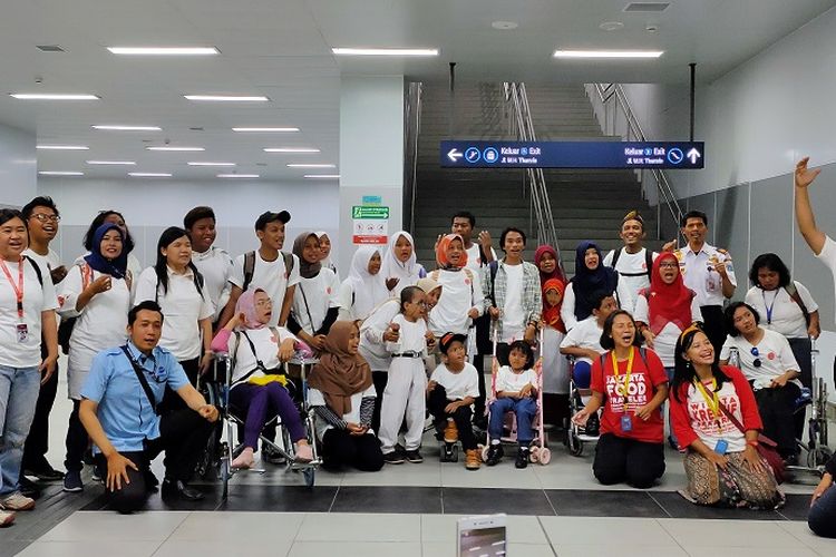 Para penyandang disabilitas bersama pemandu berfoto bersama di Stasiun MRT Bundaran HI, Jakarta, Selasa (3/12/2019).