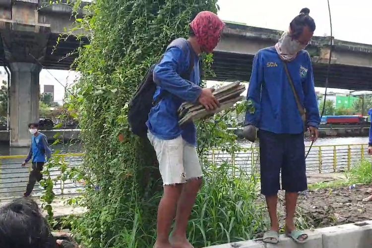 Petugas Suku Dinas Sumber Daya Air (SDA) Jakarta Utara saat mengamankan batu alam yang dicuri pelaku di taman bantaran kali Ancol, Pademangan, Jakarta Utara, Selasa (8/12/2020).