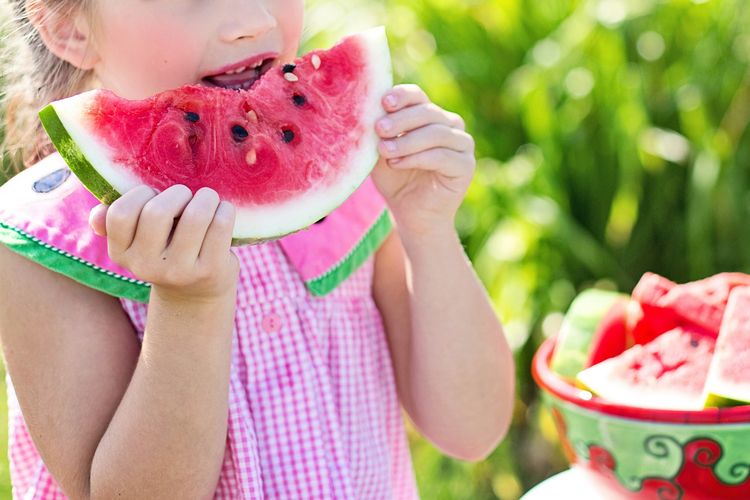 Seorang anak yang sedang memakan semangka