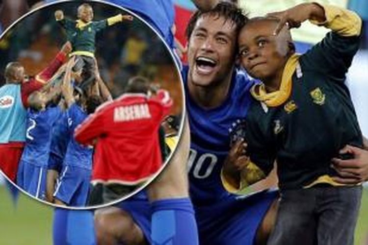 Bintang Brasil, Neymar, berfoto bersama seorang bocah seusai laga persahabatan melawan Afrika Selatan, Rabu (5/3/2014).  