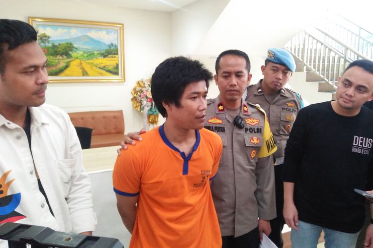 Wakapolres Gresik Kompol Erika Purwana Putra, memegangi tersangka pembunuhan anak kandung di Desa Putat lor, Kecamatan Menganti, Gresik, Jawa Timur, Sabtu (29/4/2023).