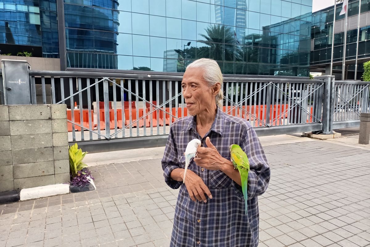 Lihat Foto Dafari (65), warga Tanah Abang, Jakarta Pusat ketika menawarkan jasa foto dengan burung peliharaanya.(Febryan Kevin/Kompas.com )