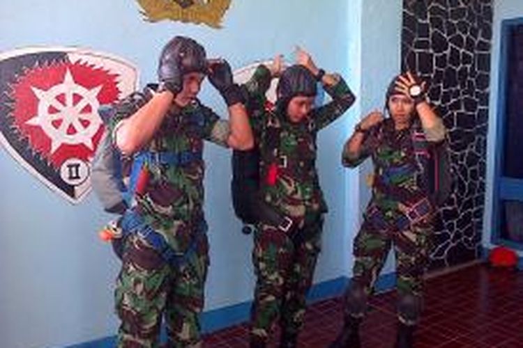 Tiga orang penerjun payung anggota TNI memperagakan cara memakai peralatan terjun sebelum melakukan aksinya. Puluhan anggota TNI dan Polri akan unjuk kebolehan terjun payung meramaikan HUT ke-50 Provinsi Sulawesi Tenggara, yang akan digelar para Minggu (27/4/2014).