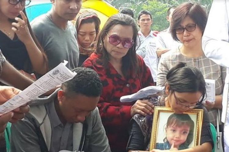 Suami istri, Jemy Ananias dan Nancy, meratapi pemakaman putri mereka, Grace Gabriela, di yang tewas dibunuh dan ditemukan di TPU Pondok Rajeg, Cibinong, Rabu (2/5/2018).
