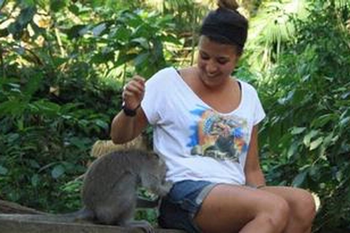 Seekor monyet merogoh saku celana turis asing yang tengah berkunjung di Monkey Forest, Ubud, Bali.