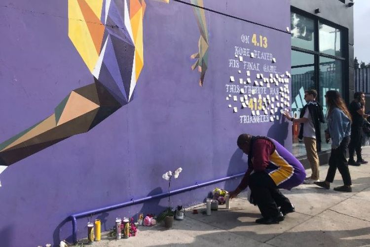 Seorang pria memberikan penghormatan untuk Kobe Bryant di mural yang ada di sisi Shoe Palace, di Los Angeles, Amerika Serikat. 

