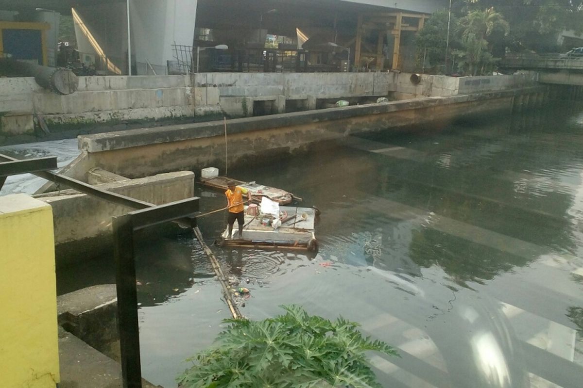 Pekerja Harian Lepas (PHL) Suku Dinas Sumber Daya Air (SDA) kota administrasi Jakarta Barat membersihkan Kali Grogol, Selasa (25/7/2017).