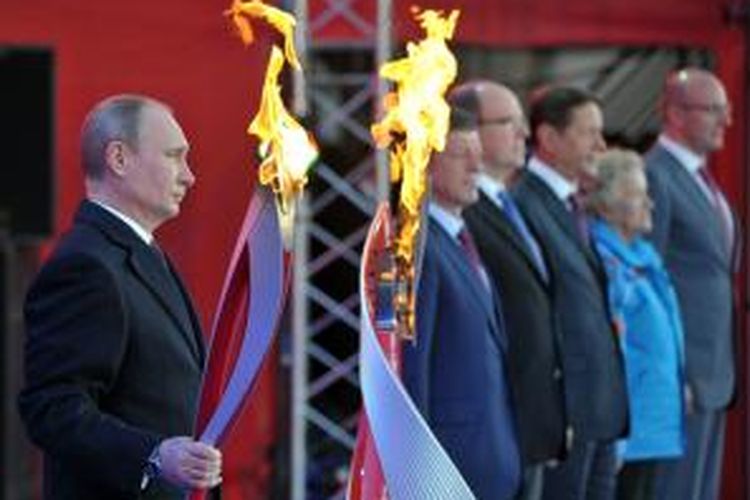 Presiden Rusia Vladimir Putin memegang obor yang menandai arak-arakan obor Olimpiade Musim Dingin yang akan digelar di kota Sochi, Rusia tahun depan.