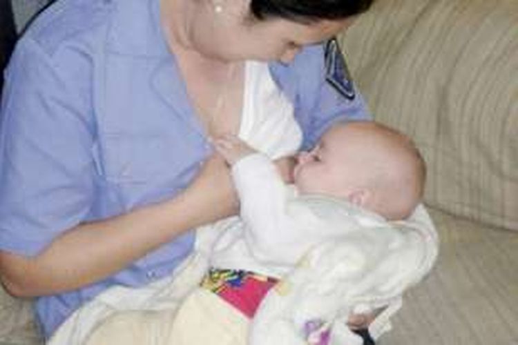 Seorang polwan yang cekatan langsung menyusui seorang bayi yang kelaparan setelah ditinggal ibunya.