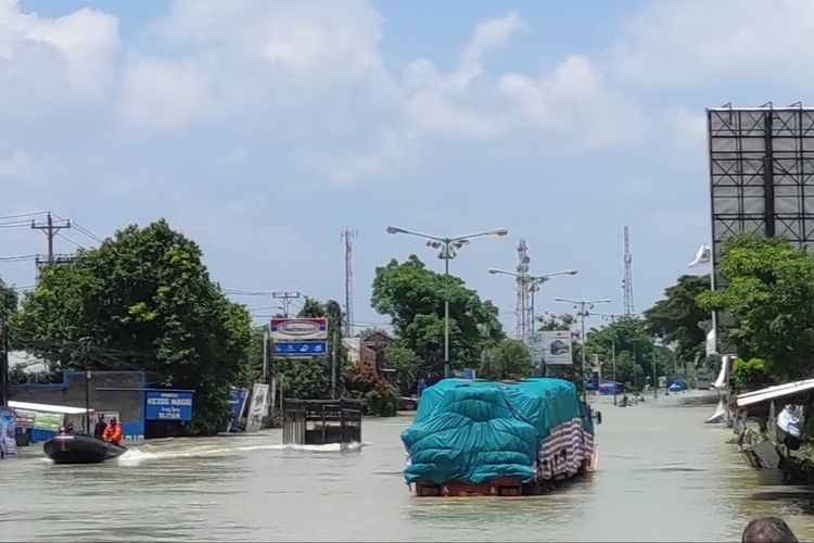 BANJIR DEMAK: Tampak kendaraan truk masih terjebak banjir di Tanggulangin, Kecamatan Karanganyar, Kabupaten Demak, Senin (12/2/2024). (KOMPAS.COM/NUR ZAIDI)