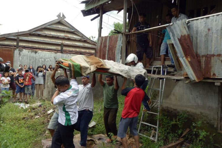 Mayat juru parkir yang ditemukan di sebuah rumah kosong di Kabupaten Bone, Sulawesi Selatan tengah dievakuasi warga. Senin, (10/7/2017).