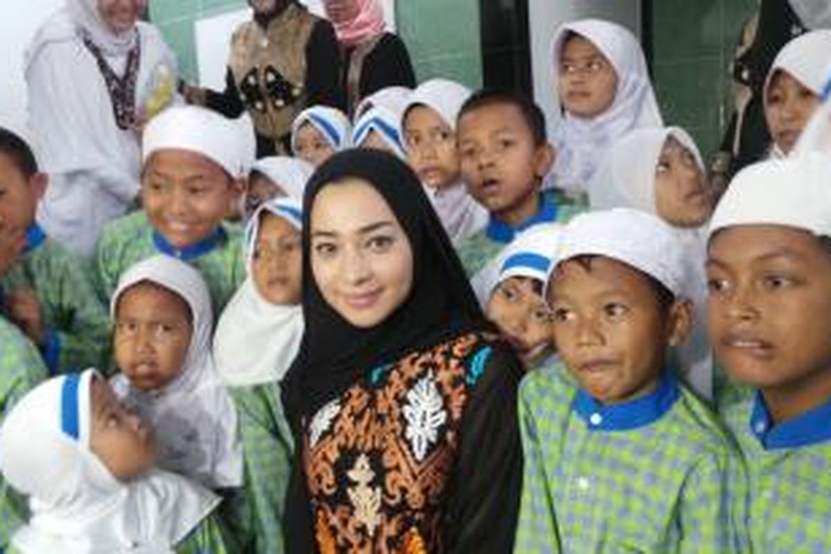 Nikita Willy di tengah anak-anak yang belajar mengaji di Taman Bacaan Al Quran Nikita Willy, kawasan Jatiwaringin, Bekasi, Jawa Barat, Selasa (19/8/2014)