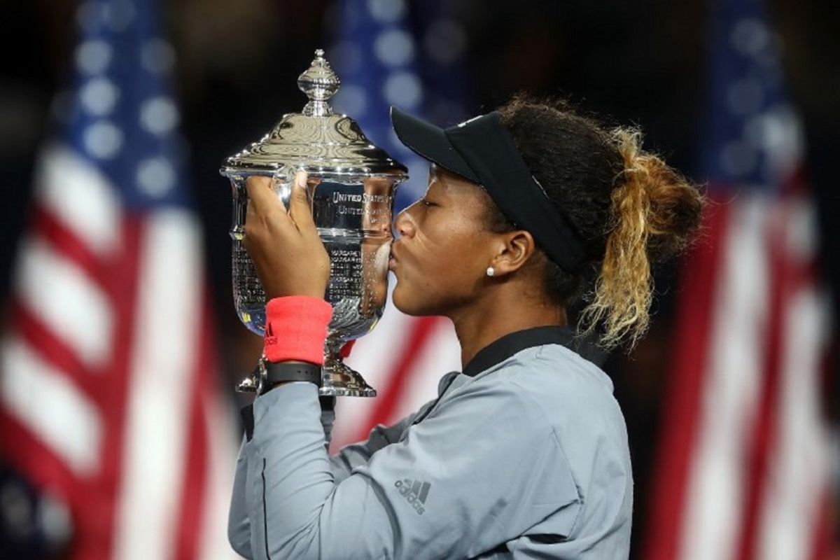 Petenis Jepang, Naomi Osaka, berpose dengan trofi juara setelah memenangi pertandingan final tunggal putri US Open 2018 melawan Serena Williams dari Amerika Serikat, Minggu (9/9/2018).