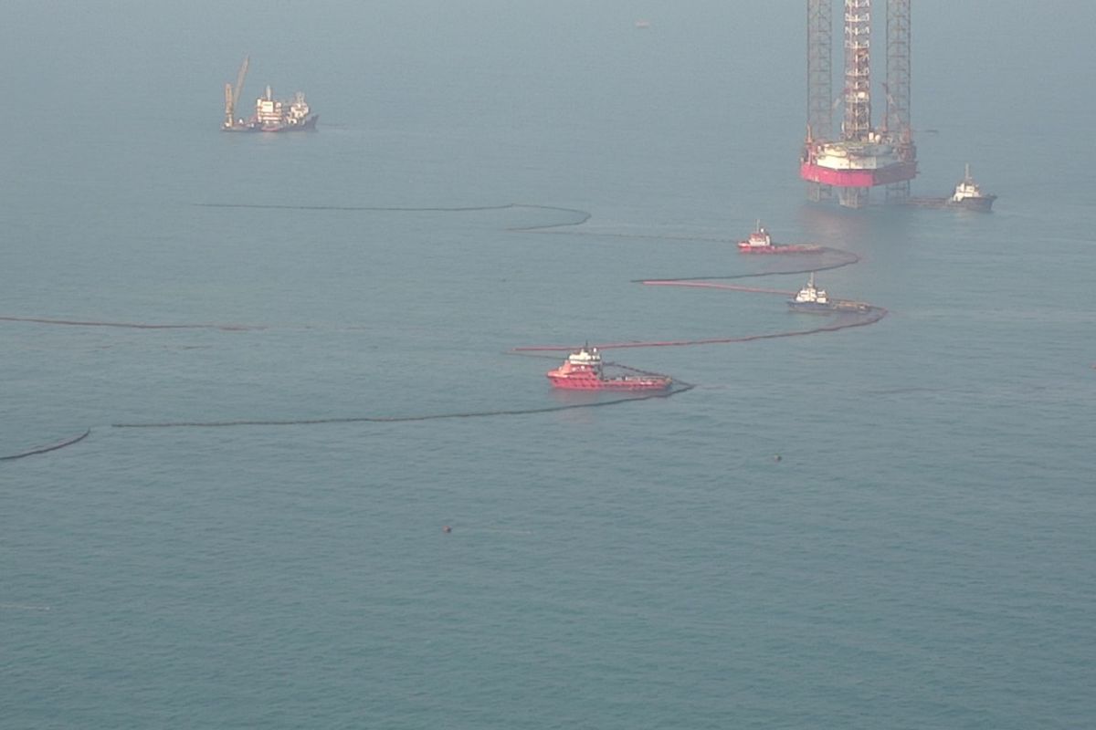 Static boom dan kapal combat milih PHE ONWJ yang bekerja membersihkan tumpahan minyak di laut