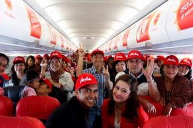 Para penumpang penerbangan pertama rute Jakarta-Medan berfoto bersama awak kabin AirAsia Indonesia dalam acara perayaan di ketinggian 30.000 kaki. 