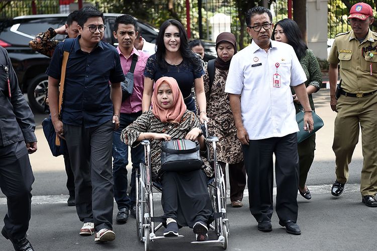 Drg Romi Syofpa Ismael (duduk di kursi roda) didampingi anggota Komisi VIII DPR Rieke Diah Pitaloka (tengah) berjalan untuk menemui Menteri Dalam Negeri (Mendagri) Tjahjo Kumolo di Jakarta, Rabu (31/7/2019). Romi yang sebelumnya gagal lolos CPNS meski menduduki peringkat pertama saat tes di Kabupaten Solok Selatan, Sumatera Barat itu mengadu ke Mendagri untuk mencari keadilan bagi dirinya.