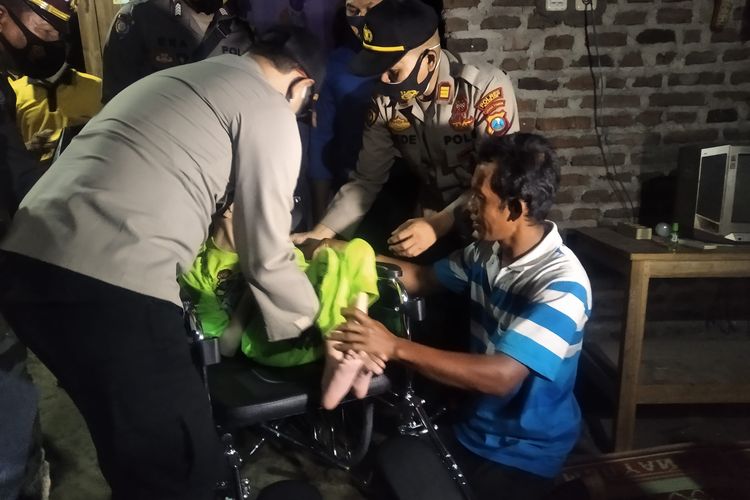 Kapolres Nganjuk AKBP Harviadhi Agung Pratama bersama Suparman membopong Hayu ke kursi roda, Jumat (5/2/2021) malam. Hayu lumpuh sejak kecil diduga kerana menderita mikrosefali.