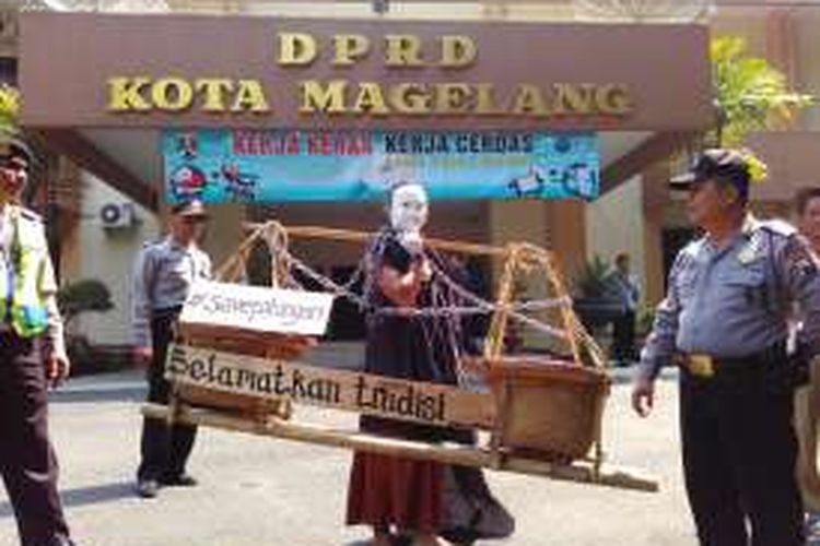 Aksi teatrikal Forum Masyarakat Menolak Relokasi Pasar Pahingan di depan gedung DPRD Kota Magelang, Kamis (28/7/2016).