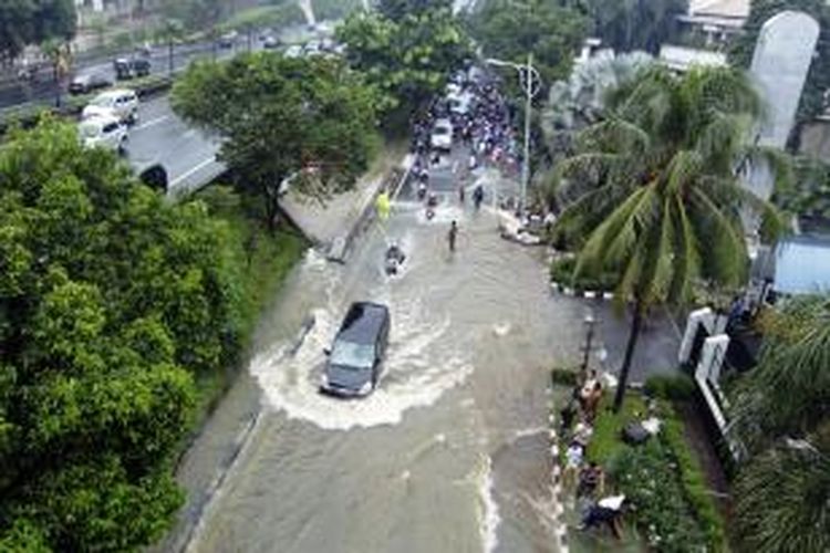 Suasana ketika sebuah mobil menerobos banjir yang terjadi di sekitar kawasan TB Simatupang, Jakarta Selatan, Senin (12/1/2014). Banjir ini terjadi akibat curah hujan yang tinggi di kawasan ibukota yang terjadi sejak Minggu malam (11/1/2014). 