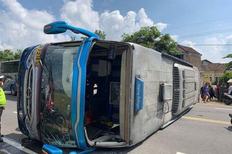  TERGULING--Bus Sugeng Rahayu jurusan Solo-Surabaya terguling setelah terlibat adu balap dengan bus lainnya di ruas jalan Madiun-Surabaya, Selasa (31/5/2022)