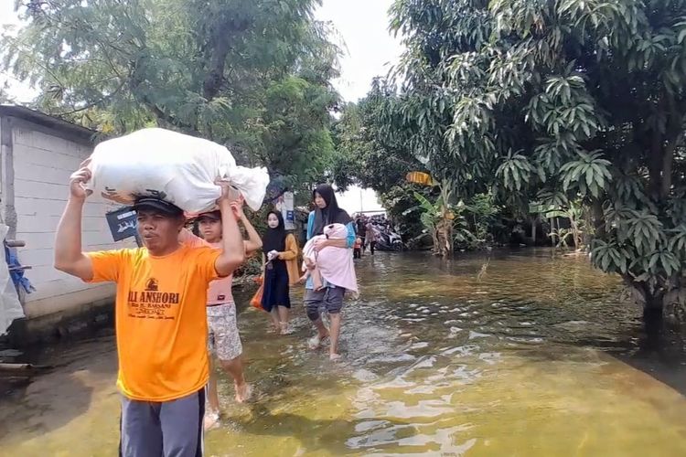 BANJIR DEMAK: Warga Desa Wonoketingal, Kecamatan Karanganyar tampak hilir mudik menengok kondisi rumah setelah tergenang banjir lebih dari sepekan, Sabtu (17/2/2024).