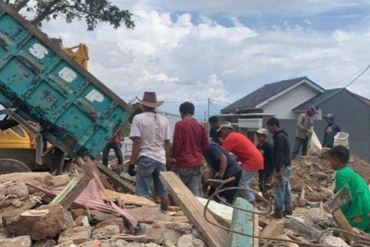 Sejumlah pengungsi gempa Cianjur memunguti besi dari sisa puing material bangunan yang rusak akibat gempa bumi.