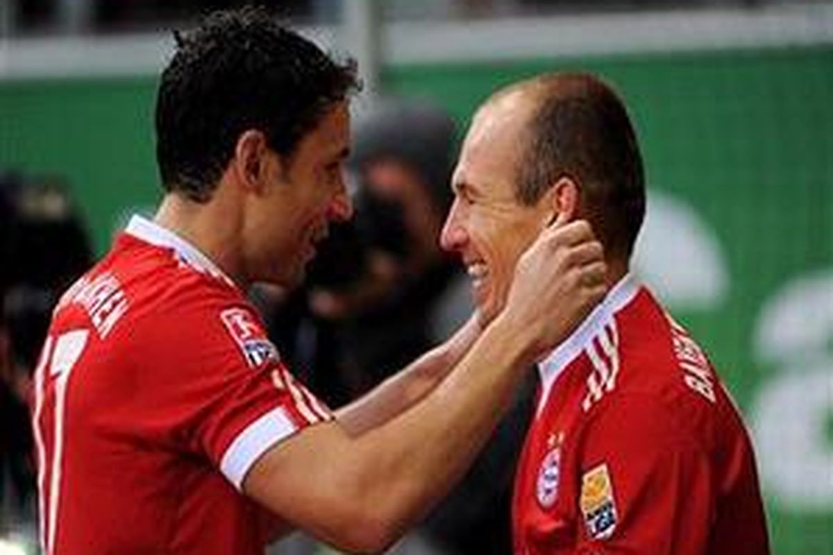 Arjen Robben (kanan) mendapat ucapan selamat dari Mark van Bommel, setelah membuka keunggulan Bayern Muenchen atas Wolfsburg. Bayern akhirnya menang 3-1.