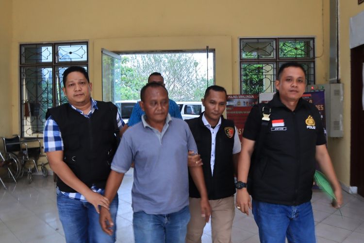 Mantan Pangulu Nagori Purwodadi, Kabupaten Simalungun Haryo Guntoro (ke dua dari kiri) digiring polisi ke Mako Polres Simalungun, Selasa (23/4/2024).