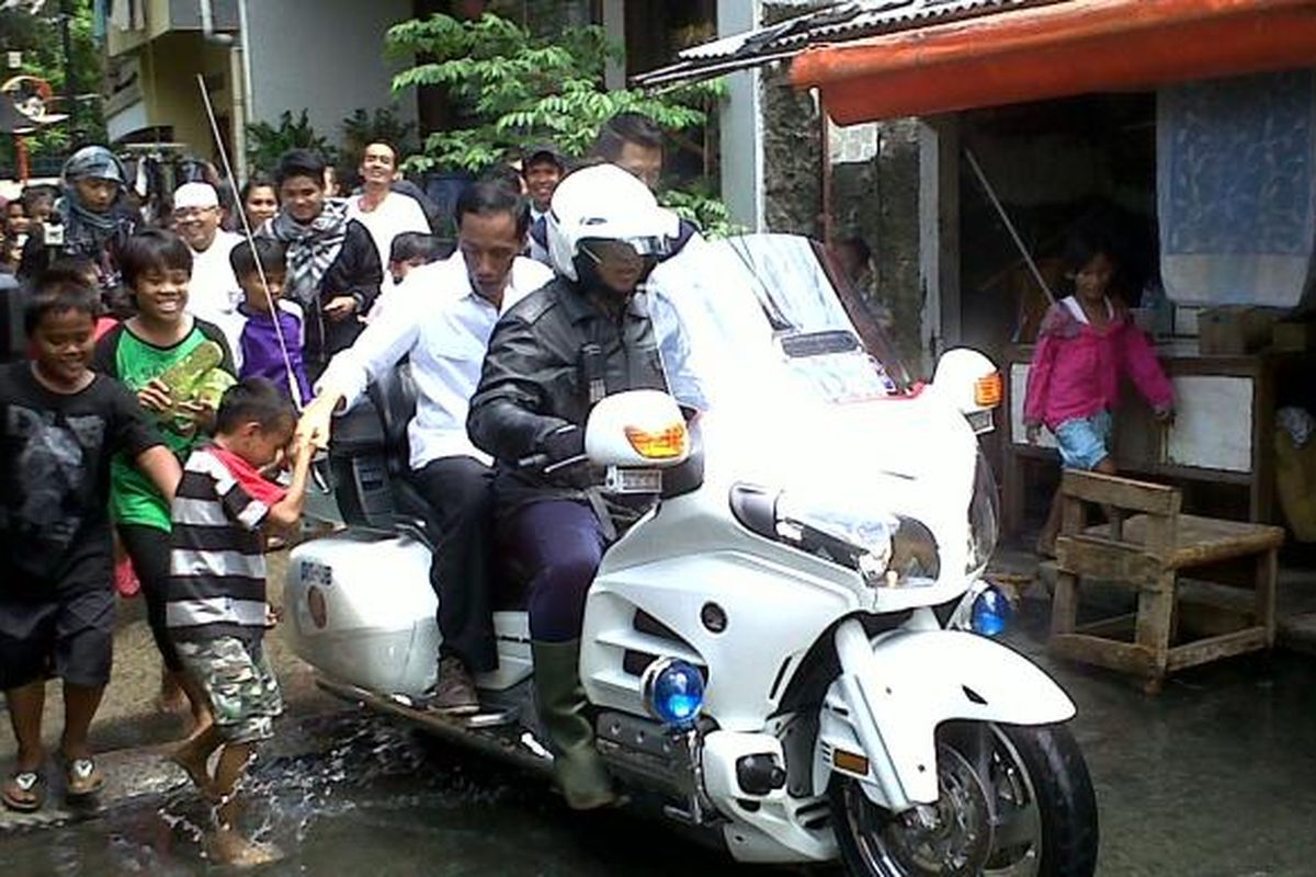 Gubernur DKI Jakarta Joko Widodo (berbaju putih) menerobos banjir Penjaringan, Jakarta Utara, Sabtu, (26/1/2013) dengan menggunakan motor gede Dinas Perhubungan DKI yang biasa ia gunakan sebagai voorijder. Di sana, ia tak hanya meninjau keadaan lokasi banjir, tapi juga memberikan bantuan berupa selimut, handuk, sembako, seragam, alat tulis, beras, dan sejumlah uang tunai.