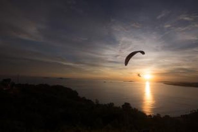 Paramotor terlihat saat matahari terbenam dari Puncak Bukit Langkisau, Kabupaten Pesisir Selatan, Sumatera Barat, Jumat (15/5/2015). Dari bukit ini wisatawan bisa menyaksikan Samudera Hindia, Pantai Salido, dan Teluk Painan.