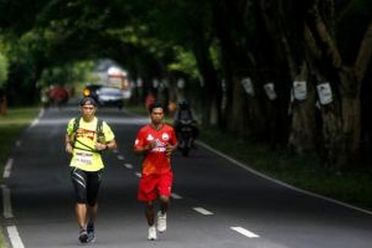 Sitor Torsina Situmorang (kiri) peserta lomba lari Trans Sumbawa dalam rangkaian Tambora Challenge 2015 lintasi Jalan Trans Sumbawa di Kecamatan Alas, Sumbawa, NTB, Rabu (8/4/2015). Lomba lari yang diikuti 8 peserta dengan 25 pelari pendamping ini dilepas dari Poto Tano dan finis di Doro Ncanga yang berjarak sekitar 320 kilometer. 