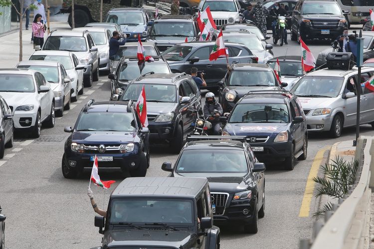 Demonstrasi menentang pemerintahan yang korup dilakukan rakyat Lebanon menggunakan mobil pada Selasa (21/4/2020). Demonstran mengendarai mobil untuk mematuhi aturan social distancing demi mencegah penyebaran Covid-19.