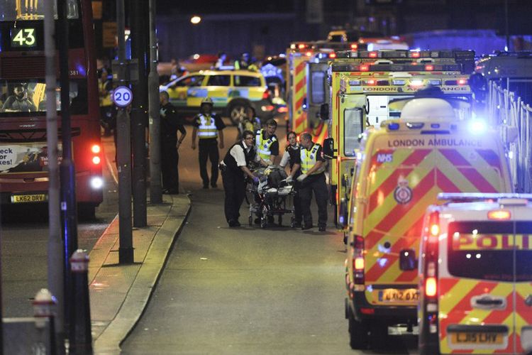 Aparat kepolisian dan petugas gawat darurat menangani seorang korban yang terluka dalam serangan di London Bridge di Kota Londong, Sabtu malam (3/6/2017).
