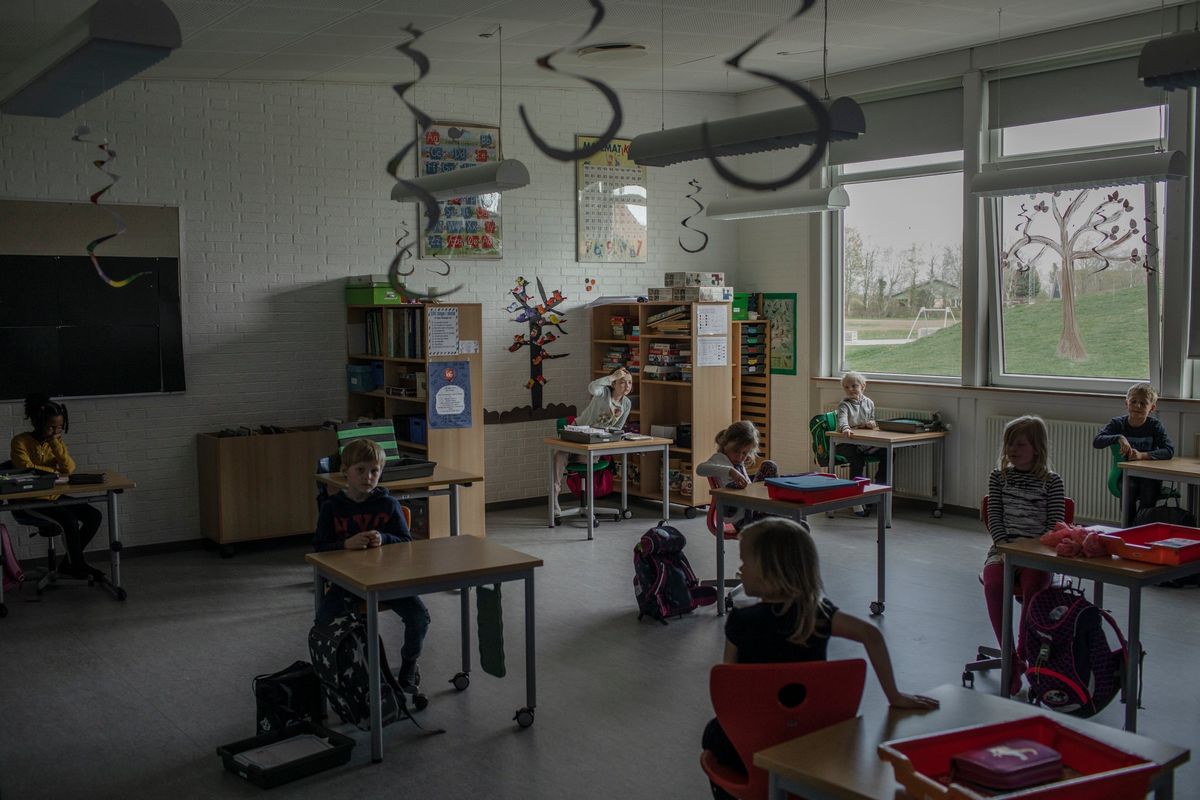 Anak-anak di Sekolah Distrik Logumkloster di Denmark duduk di meja mereka, terdampar dua meter dari tetangga terdekat mereka.