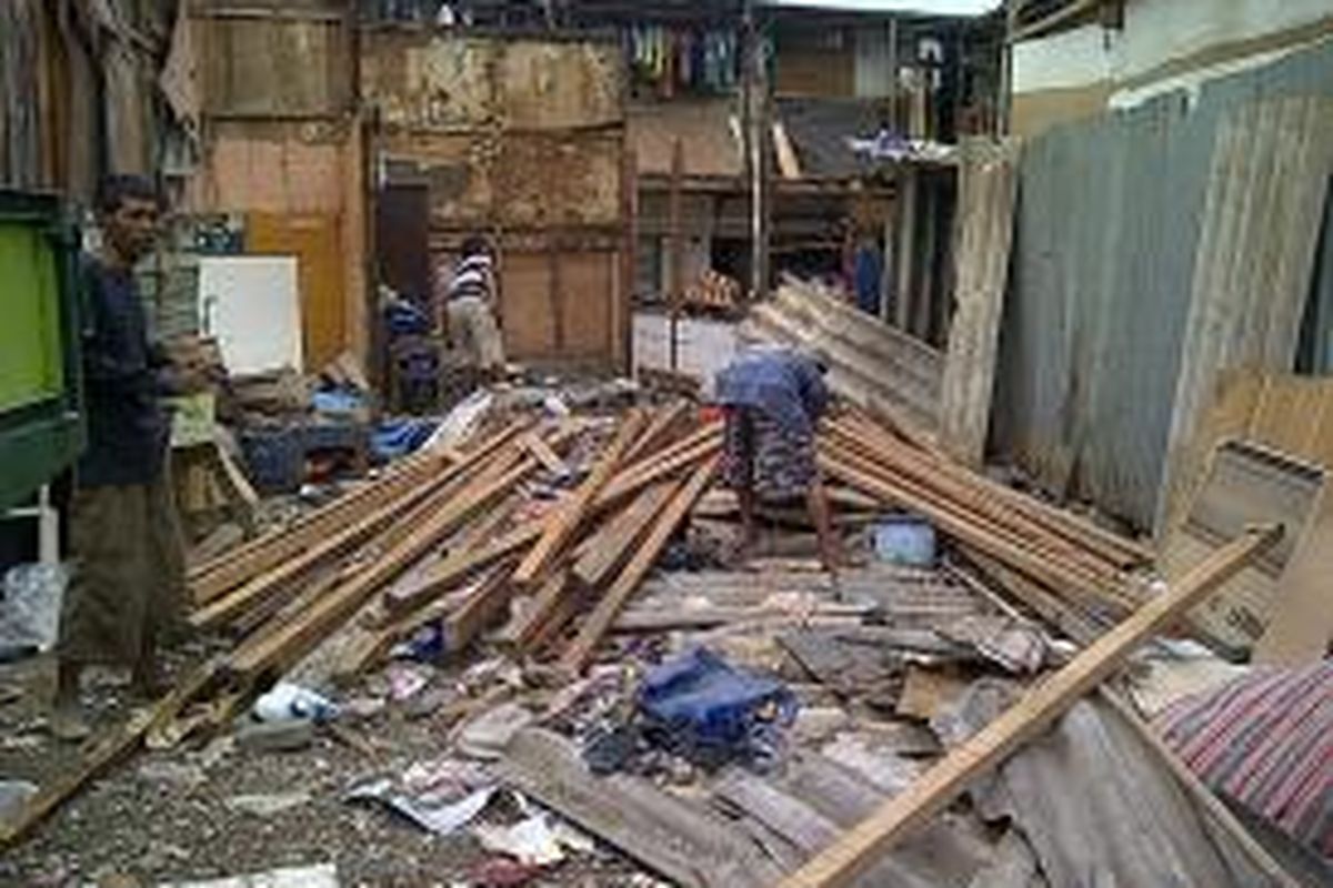 Warga di sekitar bantaran waduk Ria Rio, Jakarta Timur, membongkar rumahnya sendiri, Senin (7/10/2013). Warga bersedia direlokasi ke Rusun Pinus Elok setelah mendapatkan uang kompensasi tambahan sebesar Rp 3 juta.
