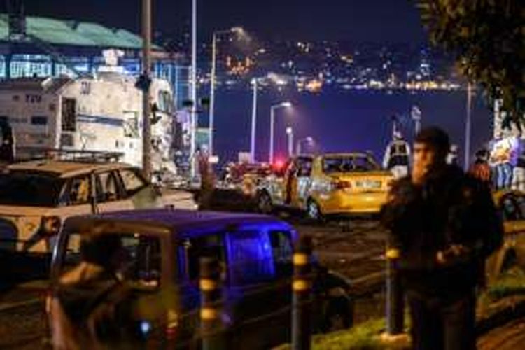 Polisi dan petugas forenksi Turki sedang berada di dekat kendaraan polisi yang rusak akibat dihantam bom, yang meleda di dekat stadion sepak bola Besiktas di pusat Istanbul, Sabtu (10/12/2016).