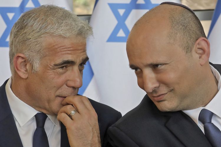 Perdana Menteri Israel Naftali Bennett (kanan) berbincang dengan Menteri Luar Negeri Israel Yair Lapid (kiri) saat rapat kabinet mingguan di Yerusalem, 29 Mei 2022.