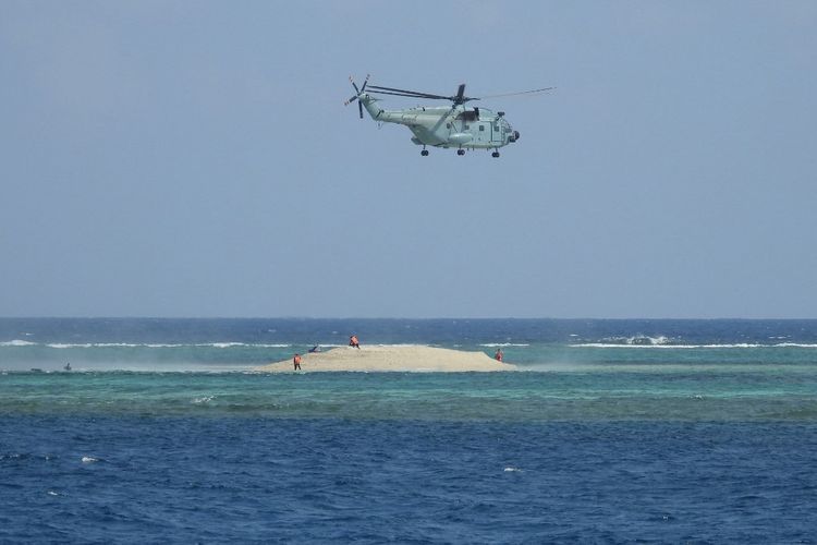 Foto yang diambil pada 23 Maret 2024 dan diterima dari Biro Perikanan dan Sumber Daya Perairan Filipina (PCG/BFAR) pada 25 Maret 2024 ini menunjukkan sebuah helikopter China melayang ketika ilmuwan Filipina menginspeksi sebuah pulau di dekat Pulau Thitu yang dikuasai Filipina, di Kepulauan Spratly, di Laut Cina Selatan yang disengketakan. Wakil menteri luar negeri dari Tiongkok dan Filipina mengadakan pembicaraan telepon yang tegang pada 25 Maret 2024, demikian ungkap Beijing, setelah Manila memanggil utusan China atas tindakan agresif yang dilakukan oleh Pasukan Penjaga Pantai China di Laut Cina Selatan yang disengketakan.