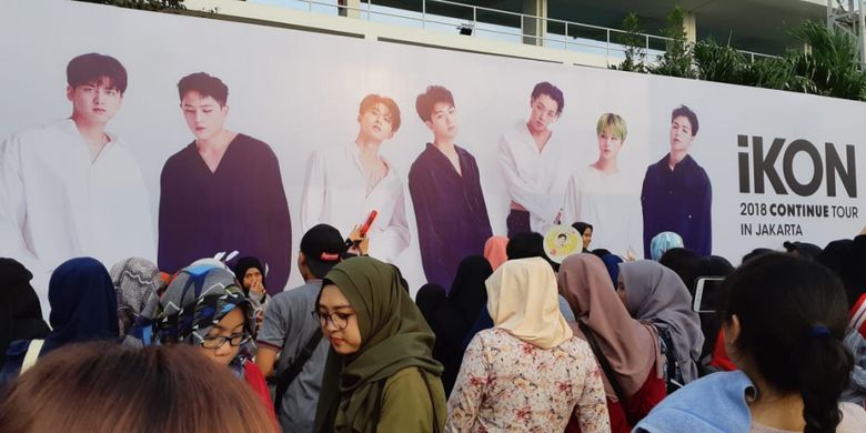 Para fans boyband iKON berkerumun di depan billboard bergambar sang idola di area Tennis Indoor Senayan, Jakarta, Minggu (18/11/2018).