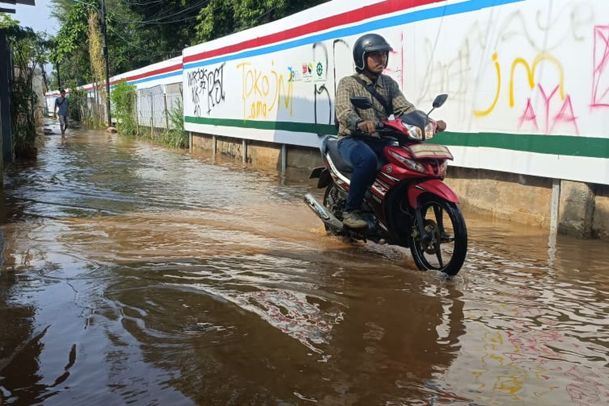 Kondisi aspal yang tergenang air di Jalan Rahayu, Kalibaru, Kramatjati, Jakarta Timur, Kamis (30/11/2023). Jalan itu tergenang air karena aspal jalanan berlubang dan debit air yang ada di aliran Kalibaru terlalu banyak.