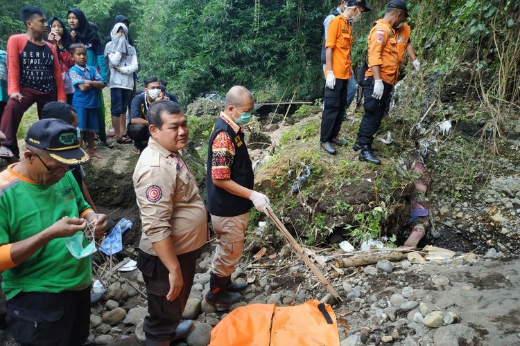 Petugas berusaha mengevakuasi mayat pria tanpa identitas terhimpit di sela-sela bebatuan di aliran Sungai Pelus, Desa Ledug, Kecamatan Kembaran, Banyumas, Jawa Tengah, Selasa (9/4/ 2019).